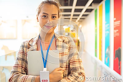 Portrait of Asian Woman Smiling Charmingly while Standing in walkway office. Portrait Of Successful Business Woman with laptop, Stock Photo