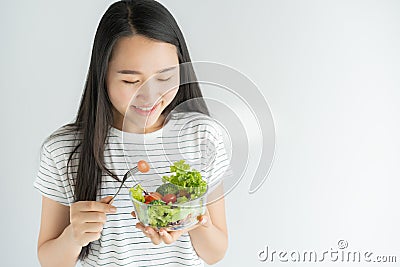 Portrait of asian woman smiling and eating salad on white background at home, Food for health care and diet Stock Photo