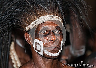 The Portrait Asmat warrior with a traditional painting and coloring on a face. Editorial Stock Photo