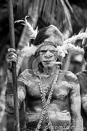 The Portrait Asmat warrior with a traditional painting and coloring on a face. Editorial Stock Photo