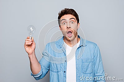 Portrait of astonished, brunet, caucasian, smart, clever, shocked guy with wide open mouth and eyes having illumination in arm, l Stock Photo