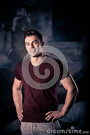 Portrait of a athletic man after doing exercises. Smiling young man in the gym smiling. Stock Photo