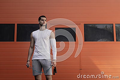 Portrait athletic, muscular man preparing for warming up with jumping rope Stock Photo