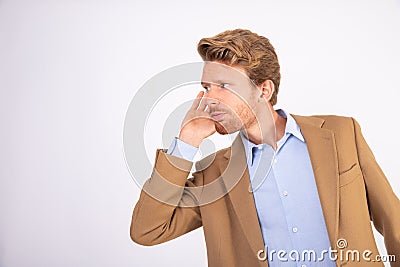 Portrait of attentive young businessman with hand over ear Stock Photo