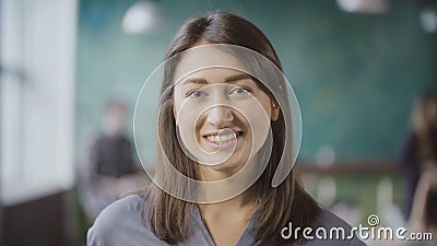 Portrait of attractive Asian businesswoman at loft office. Successful female worker turns, looks around and smiling. Stock Photo