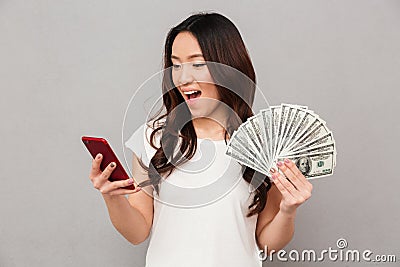 Portrait of attractive brunette female 20s winning lots of money Stock Photo