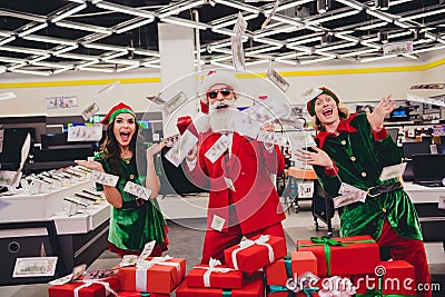 Portrait of attractive cheerful funky trendy rich wealthy group elfs wasting spending usd us having fun december at Stock Photo