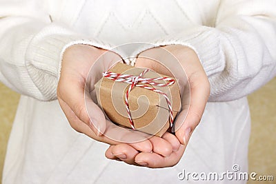 Portrait of attractive cheerful girl in sleeveless sports white shirt holding gift box with red bow over canvas background Stock Photo