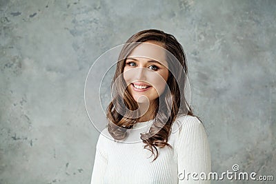 Portrait of attractive friendly casual woman smiling on gray background, portrait Stock Photo