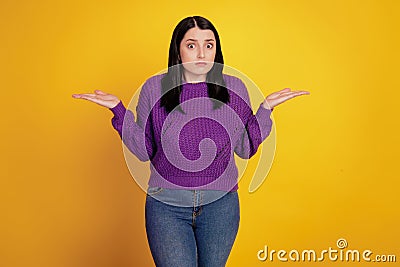 Portrait of attractive girl ignorant shrugging shoulders don't know isolated over yellow color background Stock Photo