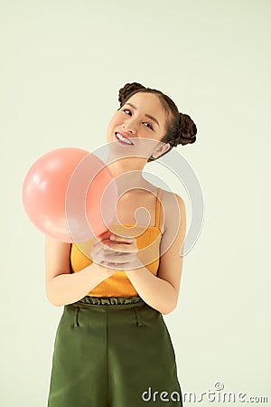 Portrait of attractive lovely gilr holding air balloon against light background Stock Photo