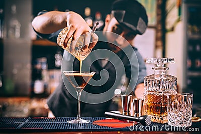 Portrait of attractive professional bartender preparing alcoholic drinks at bar Stock Photo