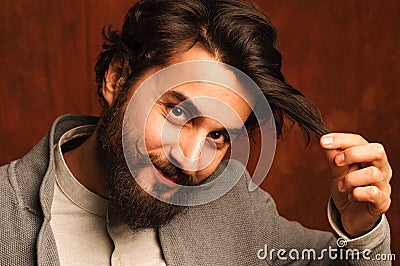 Portrait of attractive smiling man holding hair Stock Photo