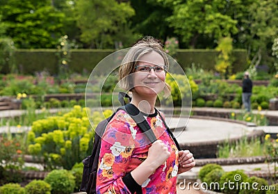 Portrait of an attractive thirty year old woman with colorful clothes and a nature park background Stock Photo