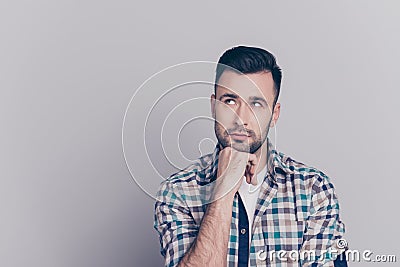 Portrait of attractive, thoughtful man holding arm on chin, having doubts, meditating, looking at copy space, standing over grey Stock Photo