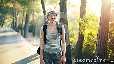 Portrait of Attractive tourist girl smiling and looking into camera while walking and hiking beautiful forest Stock Photo