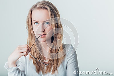 Pretty beautiful woman biting glasses in studio Stock Photo