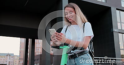 Portrait of attractive woman using alternative electric scooter in the city. New generation concept. Electric transport. Stock Photo