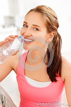 Portrait of attractive young woman drinking water at gym Stock Photo