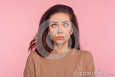 Portrait of awkward funny young woman with brunette hair making silly comical face with eyes crossed, thinking intensely Stock Photo