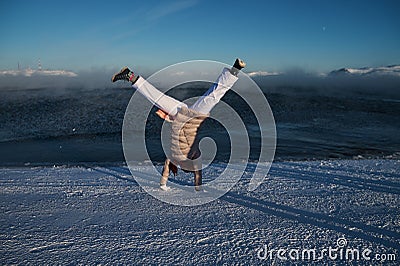 Portrait from back of warmly dressed woman in defocus standing in front of sea looking far away looking at winter rough Stock Photo