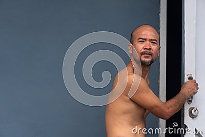 Portrait of bald beard Japanese man open white door with blue house wall Stock Photo