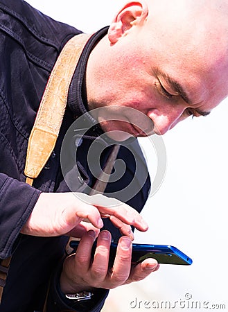 Portrait of bald elderly man looking at smartphone Stock Photo