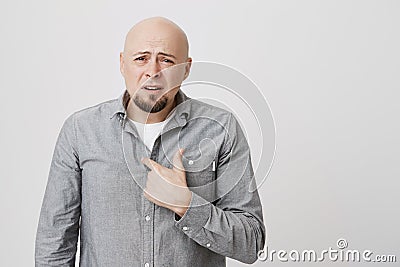 Portrait of bald handsome man with confused and questioned expression pointing at his chest. Adult male do not Stock Photo