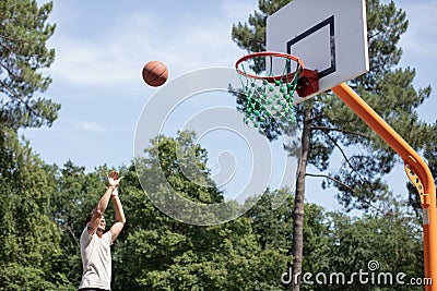 portrait basketball player taking jump shot Stock Photo