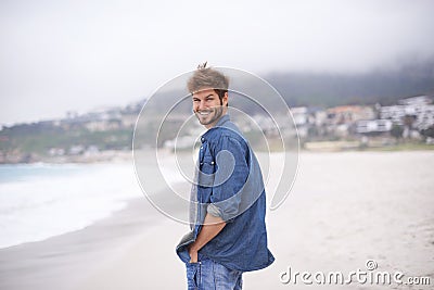 Portrait, beach and man with a smile, vacation and summer holiday with weekend break and water. Waves, face and person Stock Photo