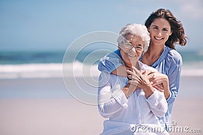 Portrait, beach and young woman with her senior mother embrace and smile together outdoors on mockup. Family, happy and Stock Photo