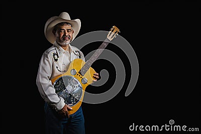 Portrait of bearded Asian musician dons cowboy attire, clutching a Dobro guitar on a black backdrop Stock Photo