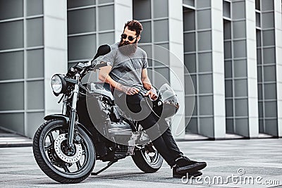 Portrait of bearded biker chilling with his motorbike Stock Photo