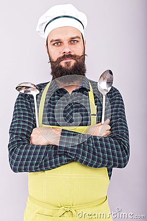 Portrait of a bearded chef holding two big kitchen utensils, lad Stock Photo