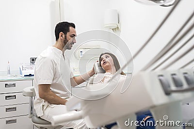 Portrait of a bearded dentist male explaining procedure to a female patient Stock Photo