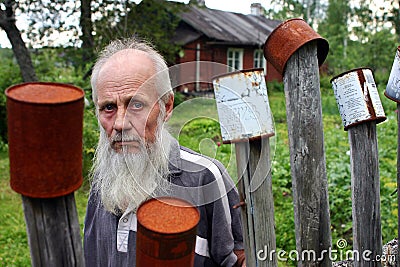 Portrait bearded old man on the background wooden farmhouse. Editorial Stock Photo