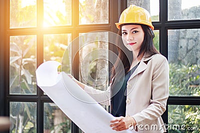 Portrait of beautiful Asian woman architect builder with yellow Stock Photo