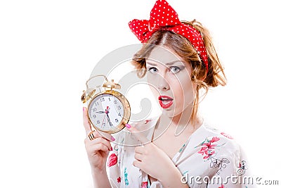 Portrait of beautiful blond pinup girl showing at 9.30 on alarm clock & looking at camera surprised on white background Stock Photo