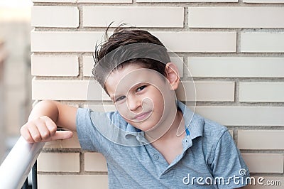 Portrait of a beautiful boy in a brick wall. Confident child, ha Stock Photo
