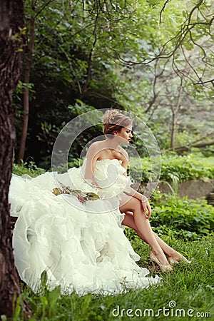Portrait of a beautiful bride woman sits in a profile and looks into the distance. Stock Photo