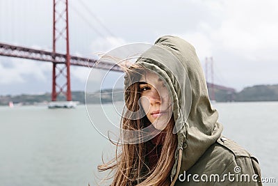 Portrait of a beautiful brunette girl with hair fluttering in the wind and with a purposeful look in the hood. 25th of Stock Photo