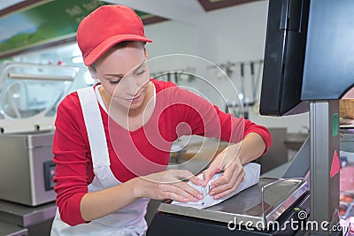 Portrait beautiful butcher packing meat in paper at shop Stock Photo