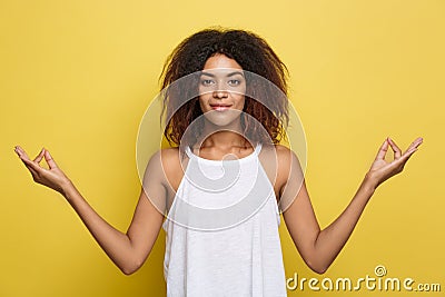 Portrait of beautiful calm young african american black female with Afro hairstyle practicing yoga indoors, meditating Stock Photo