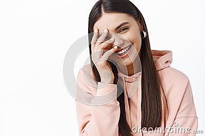 Portrait of beautiful caucasian woman laughing and covering face with hand, chuckle over something funny, express happy Stock Photo