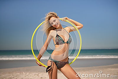 Beautiful woman standing with hula hoop ring on the beach Stock Photo