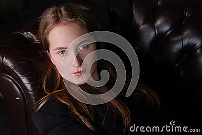 portrait of beautiful confident brunette woman in black in grey dark room. business woman. feminine. millennial people Stock Photo