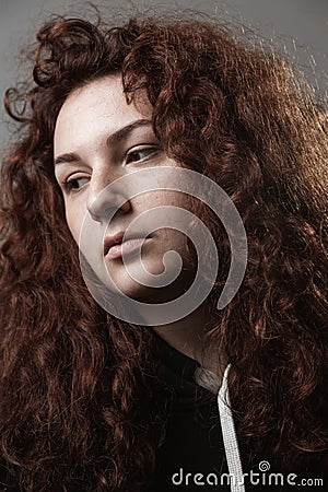 Portrait of a beautiful curly girl on a gray background Stock Photo