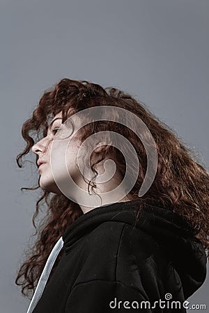 Portrait of a beautiful curly girl on a gray background Stock Photo