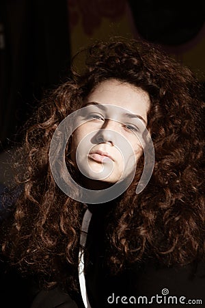 Portrait of a beautiful curly girl on a gray background Stock Photo