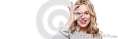 Portrait of beautiful excited woman in casual clothing smiling and showing ok sign at camera isolated over white background. Stock Photo